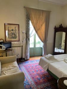 een slaapkamer met een bed, een spiegel en een bank bij Baru’s house in Palermo