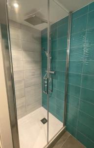 a bathroom with a shower with blue and white tiles at La Vallée d'émeraude in Plouër-sur-Rance