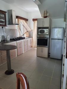 a kitchen with a refrigerator and a stove top oven at Ocean villa in Palmar
