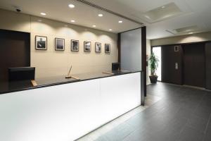 an office lobby with a reception counter with avertisement for at HOTEL MYSTAYS Hamamatsucho in Tokyo