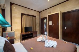 Postel nebo postele na pokoji v ubytování Hotel Lumbung Sari Legian