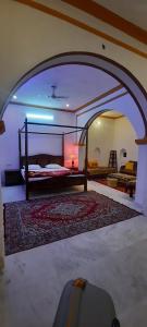 a bedroom with a bed in a room with an archway at Hotel Radhika Haveli, Mandawa in Mandāwa