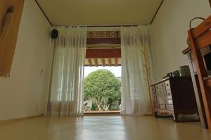 um quarto com uma grande janela com uma árvore em Daoljae Hanok Pension em Suncheon