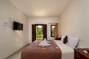 a bedroom with a large bed with flowers on it at Hotel Lumbung Sari Legian in Legian