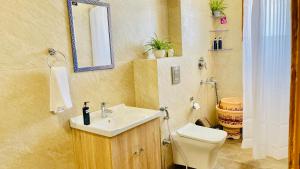 W łazience znajduje się umywalka, toaleta i lustro. w obiekcie Bedchambers Serviced Apartments, Ardee City w mieście Gurgaon