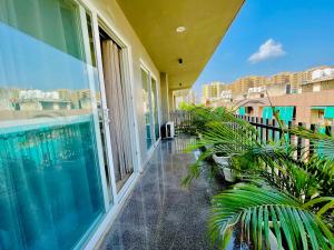 a balcony with a swimming pool and plants at Bedchambers Serviced Apartments, Ardee City in Gurgaon