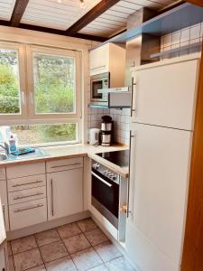 a kitchen with white appliances and a white refrigerator at Komfort-Ferienhaus Sonnental in Extertal