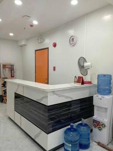 a kitchen with a counter with blue water bottles at St. Marvin Studio Makati M208 in Manila