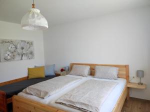 a bedroom with a wooden bed with two pillows at Haus Bübl in Presseggersee