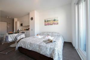 ein kleines Schlafzimmer mit einem Bett und einer Küche in der Unterkunft Sunrise House - Happy Rentals in Lugano