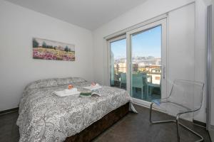a bedroom with a bed and a chair and a window at Sunrise House - Happy Rentals in Lugano