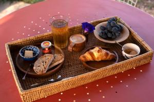 una bandeja de pan y comida en una mesa con un vaso de cerveza en Nuit insolite au milieu des vignes en Goult