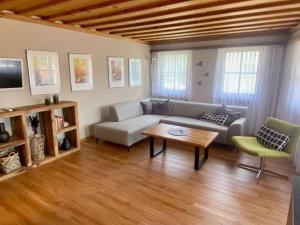 ein Wohnzimmer mit einem Sofa und einem Tisch in der Unterkunft Chasa Sager 5 in Scuol