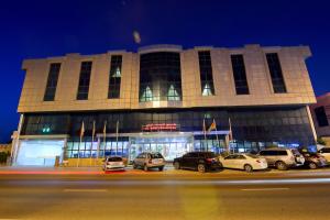 a building with cars parked in front of it at night at Al Bustan Hotel in Sharjah