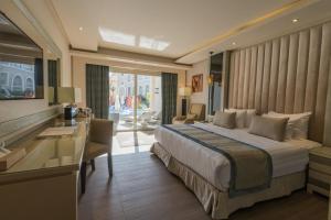 KaiSol Romance Resort Sahl Hasheesh - Adults Only في الغردقة: غرفة نوم بسرير ومكتب في غرفة