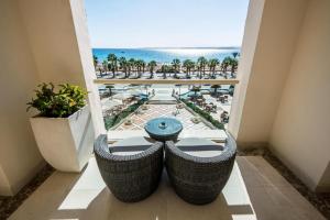balcón con mesa y vistas al océano en KaiSol Romance Resort Sahl Hasheesh - Adults Only, en Hurghada