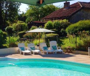 a group of chairs and an umbrella next to a pool at Cardabelle Holiday Home with private garden in Mazières