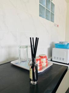 un jarrón de cristal con palos en la encimera de la cocina en Condo popular T8 fl.6, en Thung Si Kan