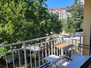 een balkon met 2 stoelen en een tafel. bij Community Park Apartment in Niš