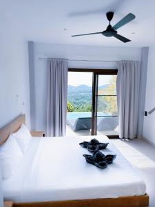 a bedroom with a bed with a ceiling fan at Mantra Sea View Villa in Chaloklum