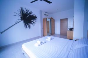 ein Schlafzimmer mit einem großen weißen Bett und zwei weißen Handtüchern in der Unterkunft Mantra Sea View Villa in Chaloklum
