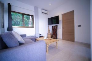 a living room with a couch and a table and a door at Mantra Sea View Villa in Chaloklum