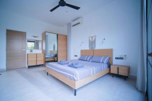 a bedroom with a large bed and a mirror at Mantra Sea View Villa in Chaloklum