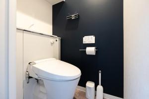 a bathroom with a white toilet and a black wall at LUXE Minami Aoyama in Tokyo