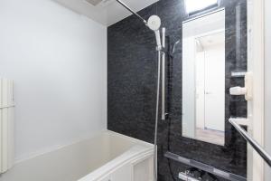 a bathroom with a white tub and a mirror at LUXE Minami Aoyama in Tokyo