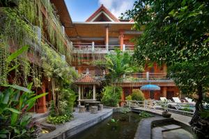 a building with a pond in front of it at Hotel Lumbung Sari Legian in Legian