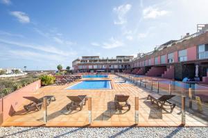 eine Terrasse mit Stühlen und einen Pool auf einem Gebäude in der Unterkunft Marfolin 22 in Cotillo