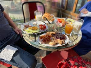 a table with plates of food and drinks on it at Central Cozy Apartment Old Train Station in Tirana