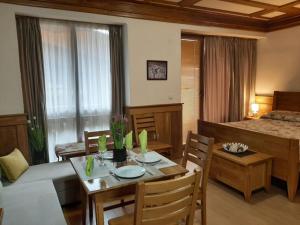 ein Wohnzimmer mit einem Esstisch und ein Schlafzimmer in der Unterkunft Private Studio Pirin Golf Hotel Bansko in Raslog