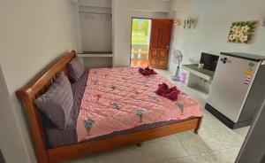 チャウエンにあるPott Guesthouseのベッドルーム1室(ピンクの掛け布団、冷蔵庫付)