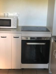 a kitchen with a stove and a microwave at Grande chambre avec salle de bain privative à Nanterre Préfecture proche La Défense Aréna Campus SNCF et Paris in Nanterre