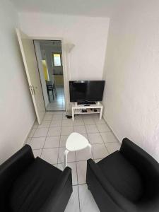 ein Wohnzimmer mit zwei schwarzen Sofas und einem TV in der Unterkunft Schöne Wohnung in der Via Borgo in Ascona