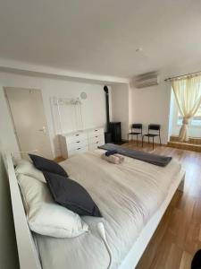 ein großes weißes Bett in einem Zimmer mit einem großen Fenster in der Unterkunft Schöne Wohnung in der Via Borgo in Ascona