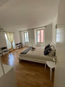 ein großes weißes Schlafzimmer mit einem großen Bett und Holzböden in der Unterkunft Schöne Wohnung in der Via Borgo in Ascona