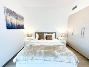 1 dormitorio blanco con 1 cama grande y 2 lámparas en Casa Dei Ricordi 620WB8, en Abu Dabi
