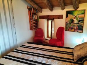 a bedroom with two red chairs and a bed at CASA BONITA in Morella