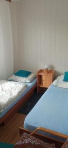 een kamer met 2 bedden en een houten nachtkastje bij Privat Ludmila in Liptovská Teplička
