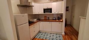 uma cozinha com armários brancos e um frigorífico em Bonito apartamento Cádiz centro em Cádiz