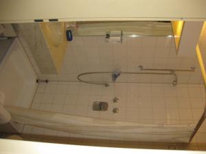 ein Bad mit einer Badewanne in einem gefliesten Zimmer in der Unterkunft Abakus-Hotel in Sindelfingen