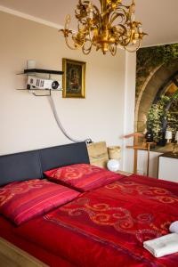 Schlafzimmer mit einem roten Bett und einem Kronleuchter in der Unterkunft Zentrum und Whirlpool 107m2 Händel-Suite by Meis - Perfekt für längere Aufenthalte! in Halle an der Saale