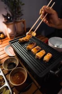 a person cooking food on a grill with chopsticks at Northland Pai in Pai