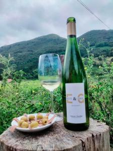 una botella de vino y un plato de comida y una copa de vino en Agroturismo Erlete Goikoa -ESTAMOS EN EL CAMINO DE SANTIAGO -WE ARE ON THE CAMINO DE SANTIAGO, en Deba