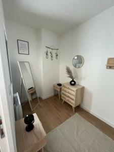 een woonkamer met een tafel en een spiegel bij Hyper centre T2 Haut standing in Maubeuge