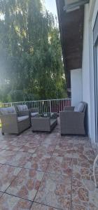 un patio con sofás y sillas en un porche en Apartment Plavo oko, en Smoljanac