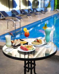 a table with food and drinks next to a swimming pool at Rio Boutique in Candolim