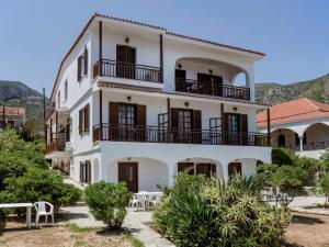 a white building with tables and chairs in front of it at Villa Diamanti in Monemvasia